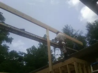 Carpenter setting a ridge beam over a new addition frame — Ice Dam Removal by Roofing Brothers in Darien