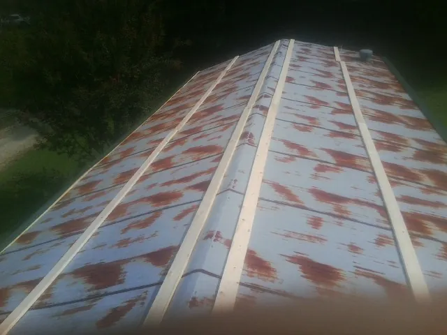 Rusted metal roof panels with new wood purlins before replacement — Storm Damage Roof Repair in Darien by Roofing Brothers